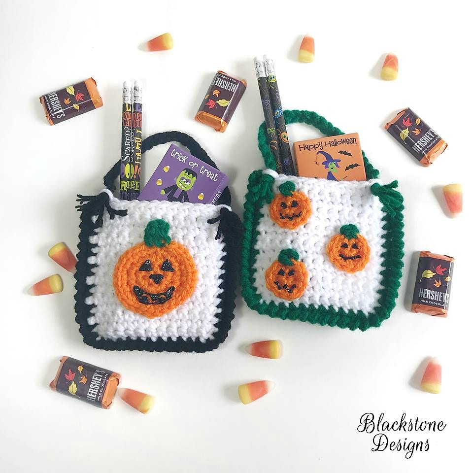Two crochet treat bags filled with candy and pencils designed like jack o lanterns.
