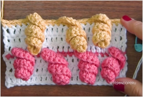 a person is holding a crocheted piece of yarn.