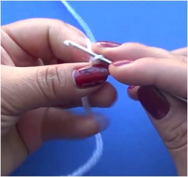 a person is holding a knitting needle and a crochet hook.
