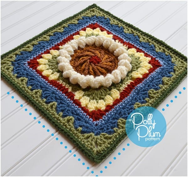 a crocheted square with a flower on it.