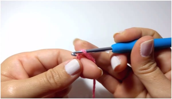 a person is using a blue tool to make a crochet stitch.