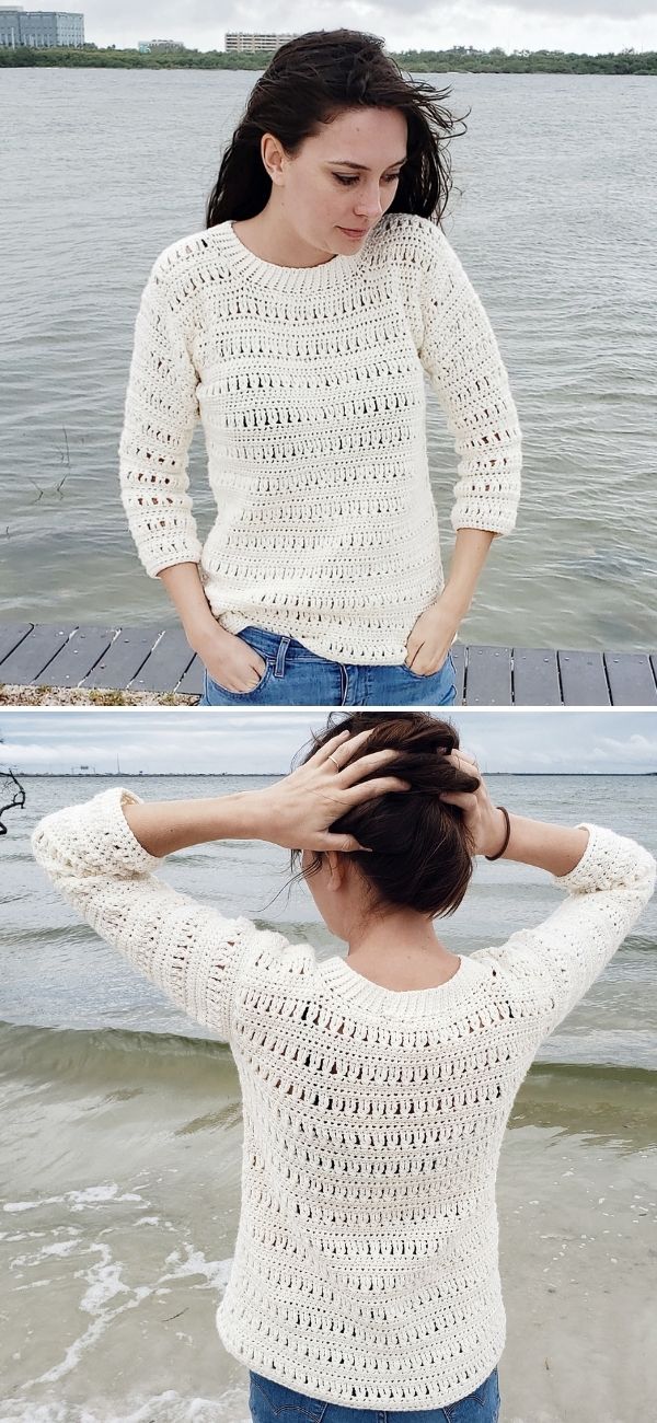 a woman in front of a lake wearing a crochet lacy sweater with blue jeans