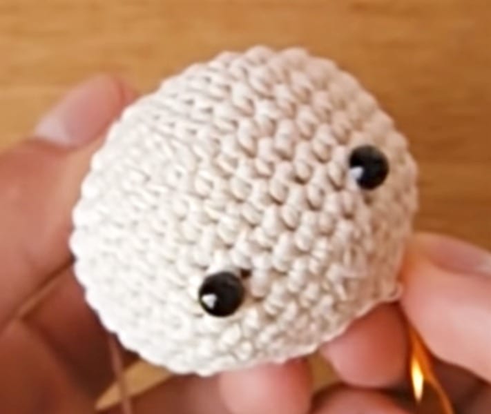 A person is holding a crocheted octopus.