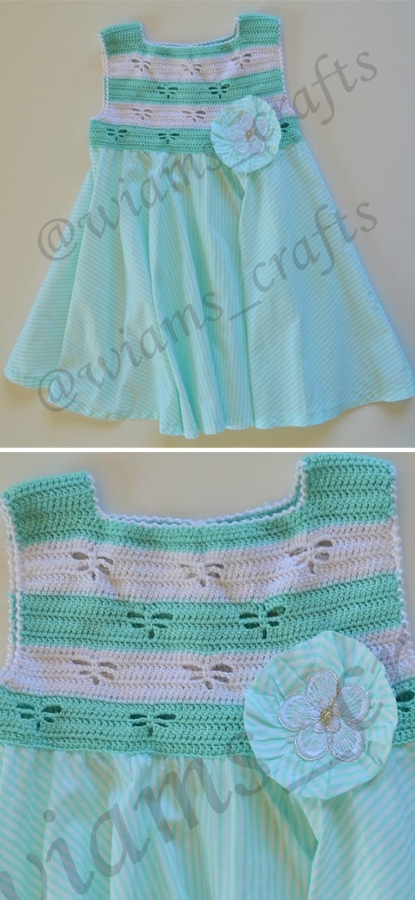 A turquoise and white crocheted baby dress featuring a flared skirt and a flower detail on the bodice, perfect for any little one to look adorable in during a family CAL gathering.