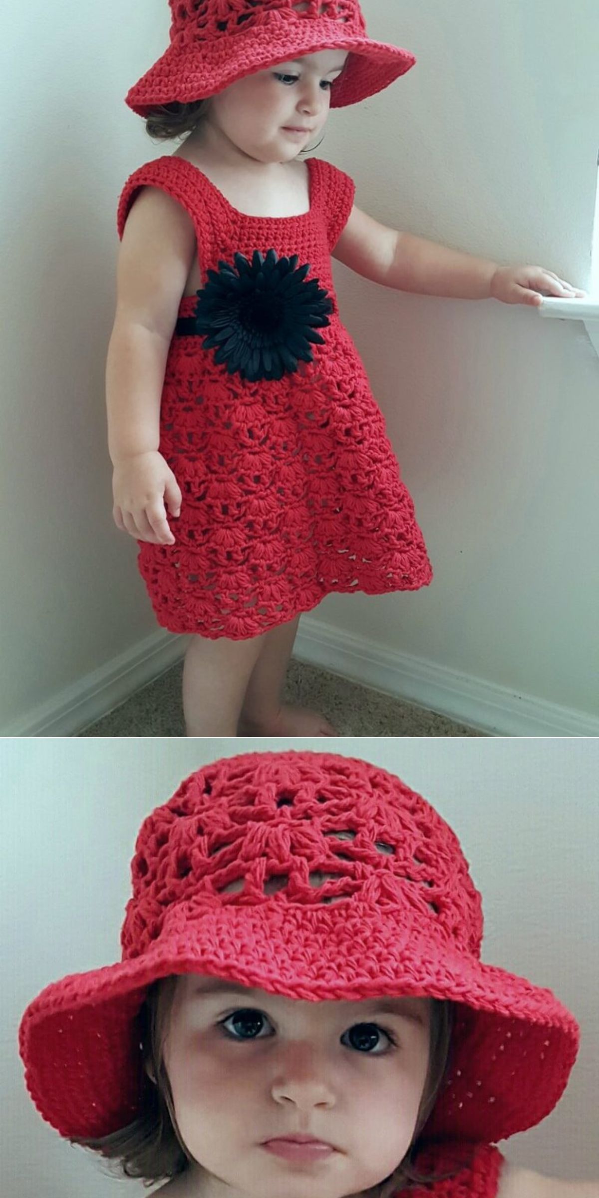 A young child wearing a charming crochet dress with a large black flower and a matching red crocheted hat stands by a window.
