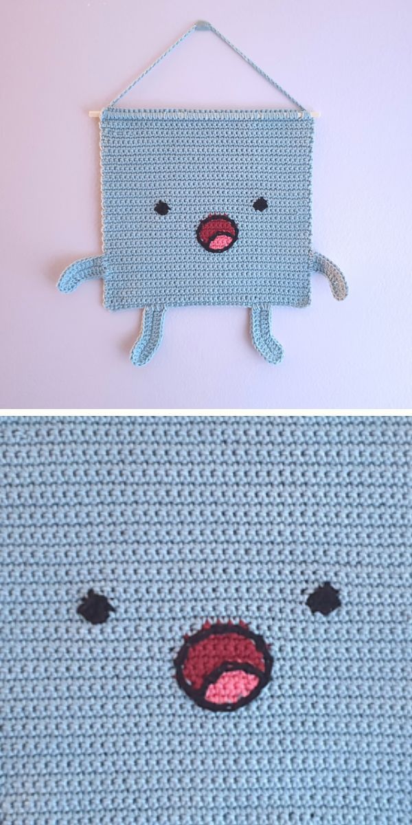 A crocheted wall hanging featuring a face.