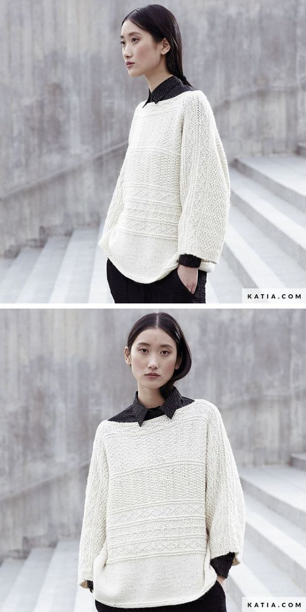A woman is posing in a white knitted sweater and black pants.