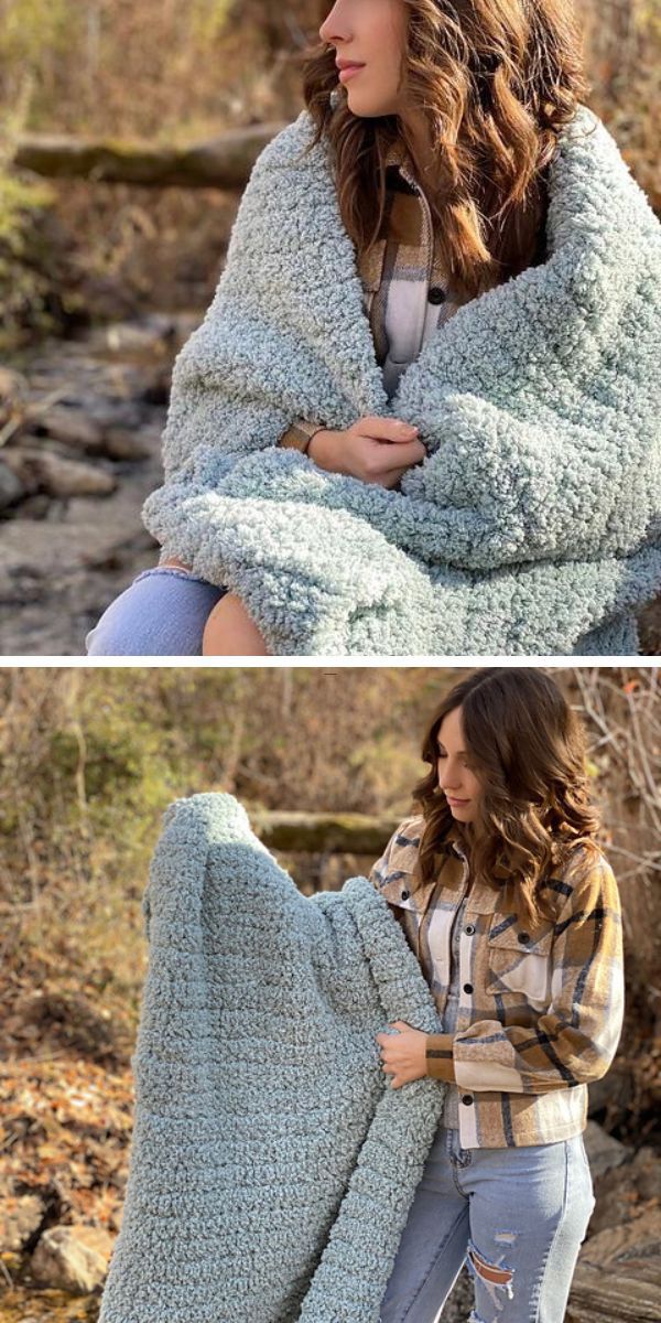 A woman wrapped in a modern crochet blanket stands outdoors near a stream, with a focus on comfort and nature.