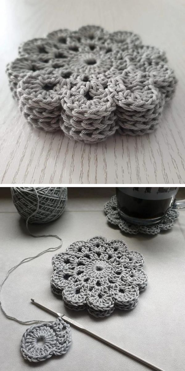 Hand-crocheted grey flower coasters of varying sizes displayed on a light surface along with crochet materials.