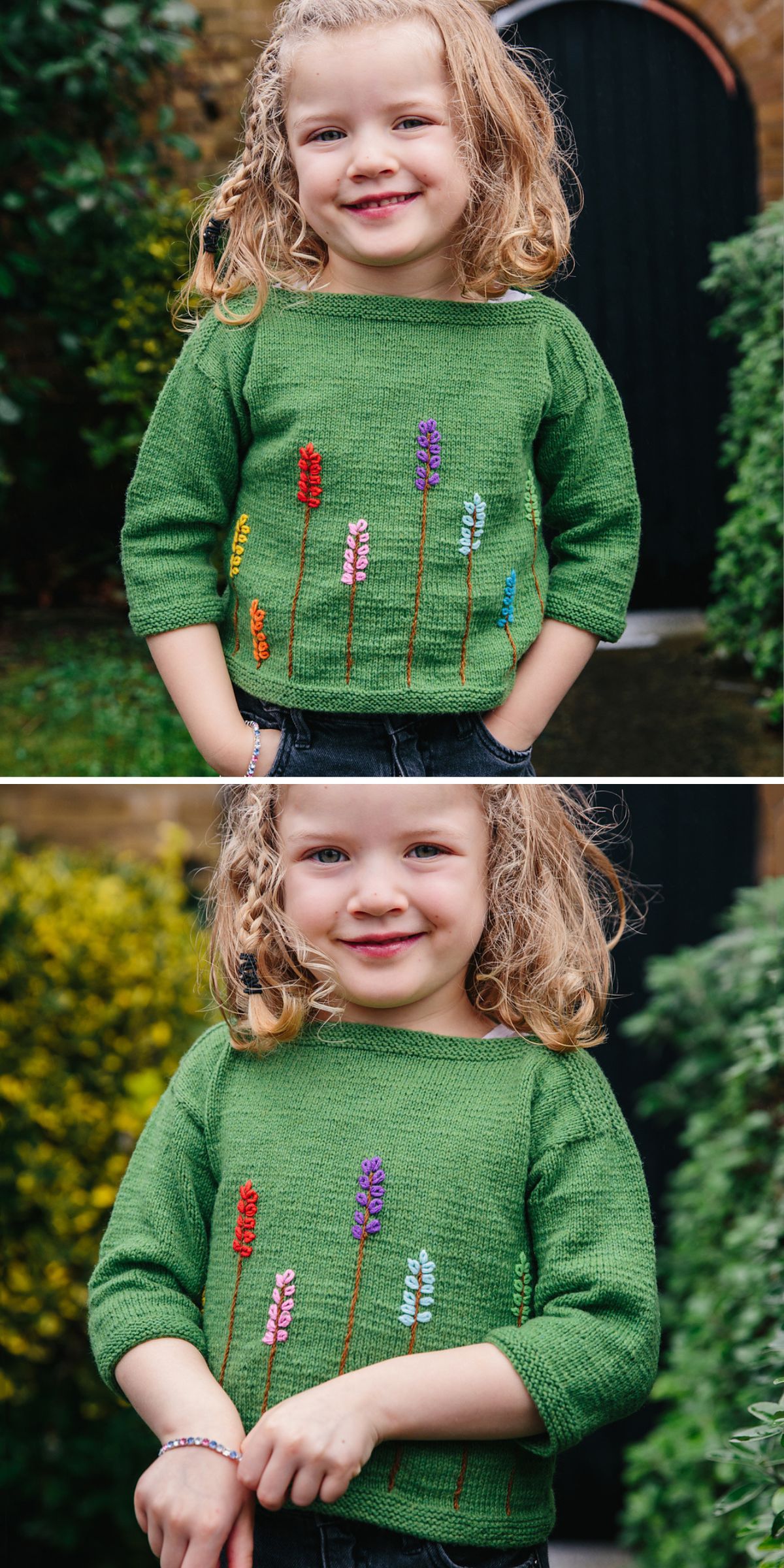 A child wearing a green knitted baby sweater adorned with colorful flower designs stands in a garden, surrounded by vibrant plants and a dark door in the background.