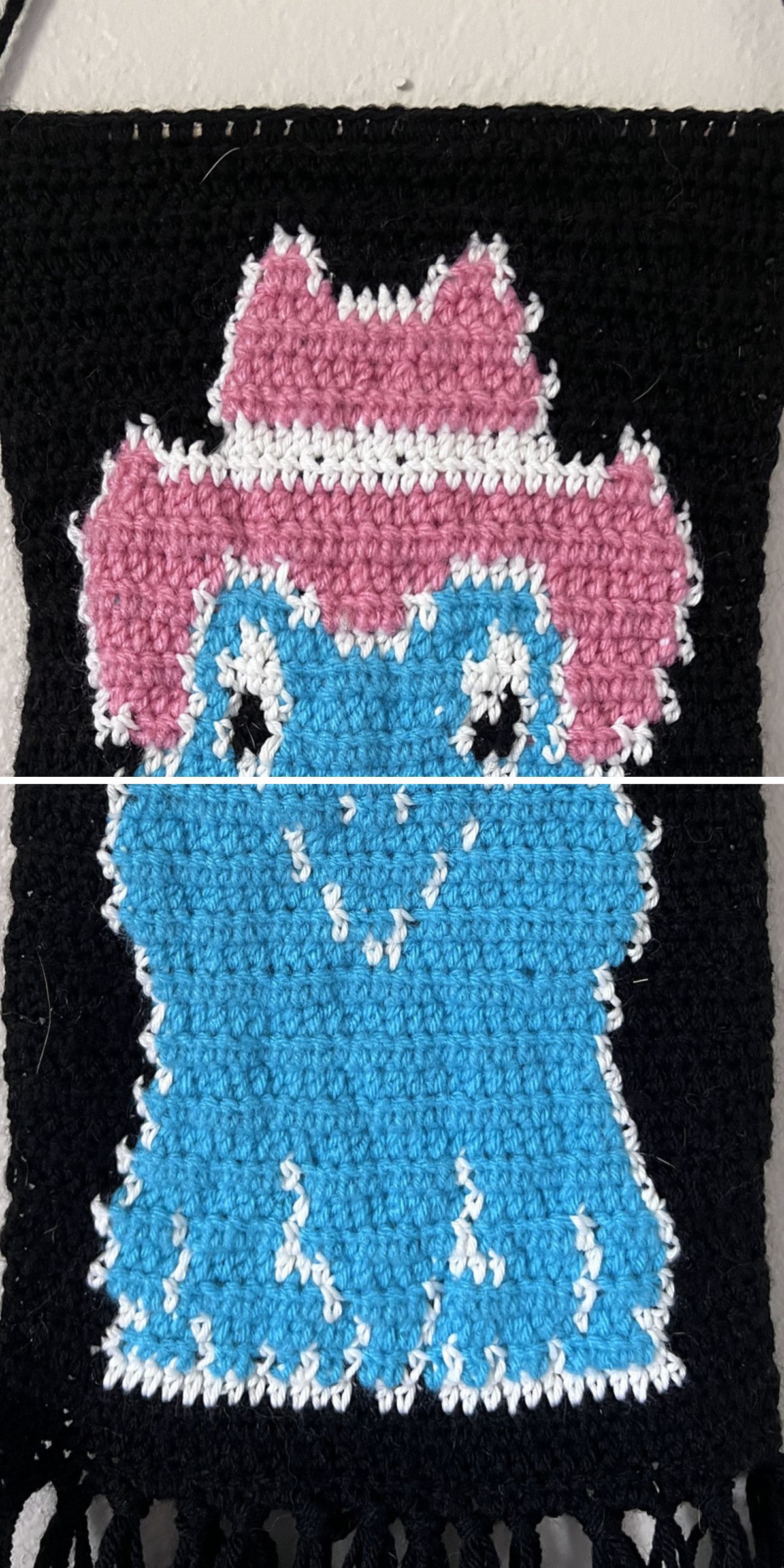 This crochet wall hanging features a whimsical blue frog sporting a pink cowboy hat, perfectly set against a black background.