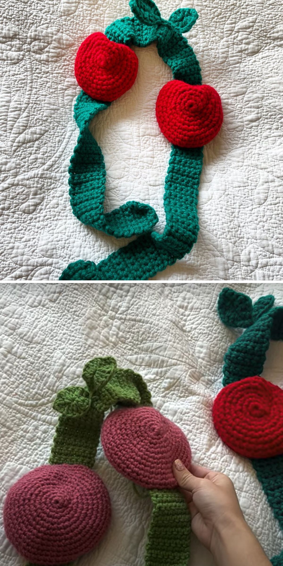 A crocheted headband resembling fruit on a vine, featuring red and pink round shapes with textured green leaves.