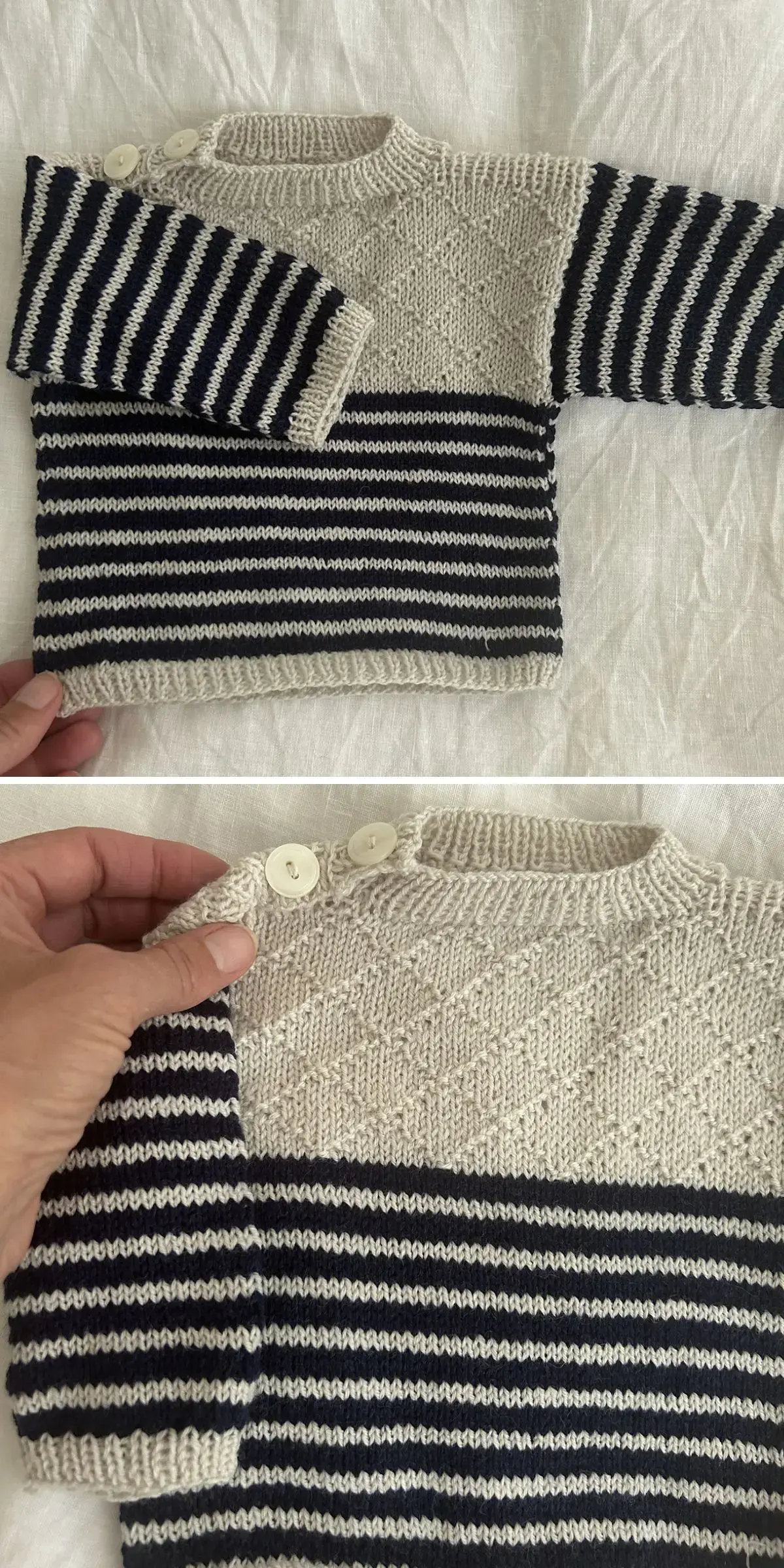 A knitted baby sweater with black and white stripes features two buttons on the shoulder. In the close-up, a hand gently holds one shoulder, showcasing the fine detail of this cozy garment.