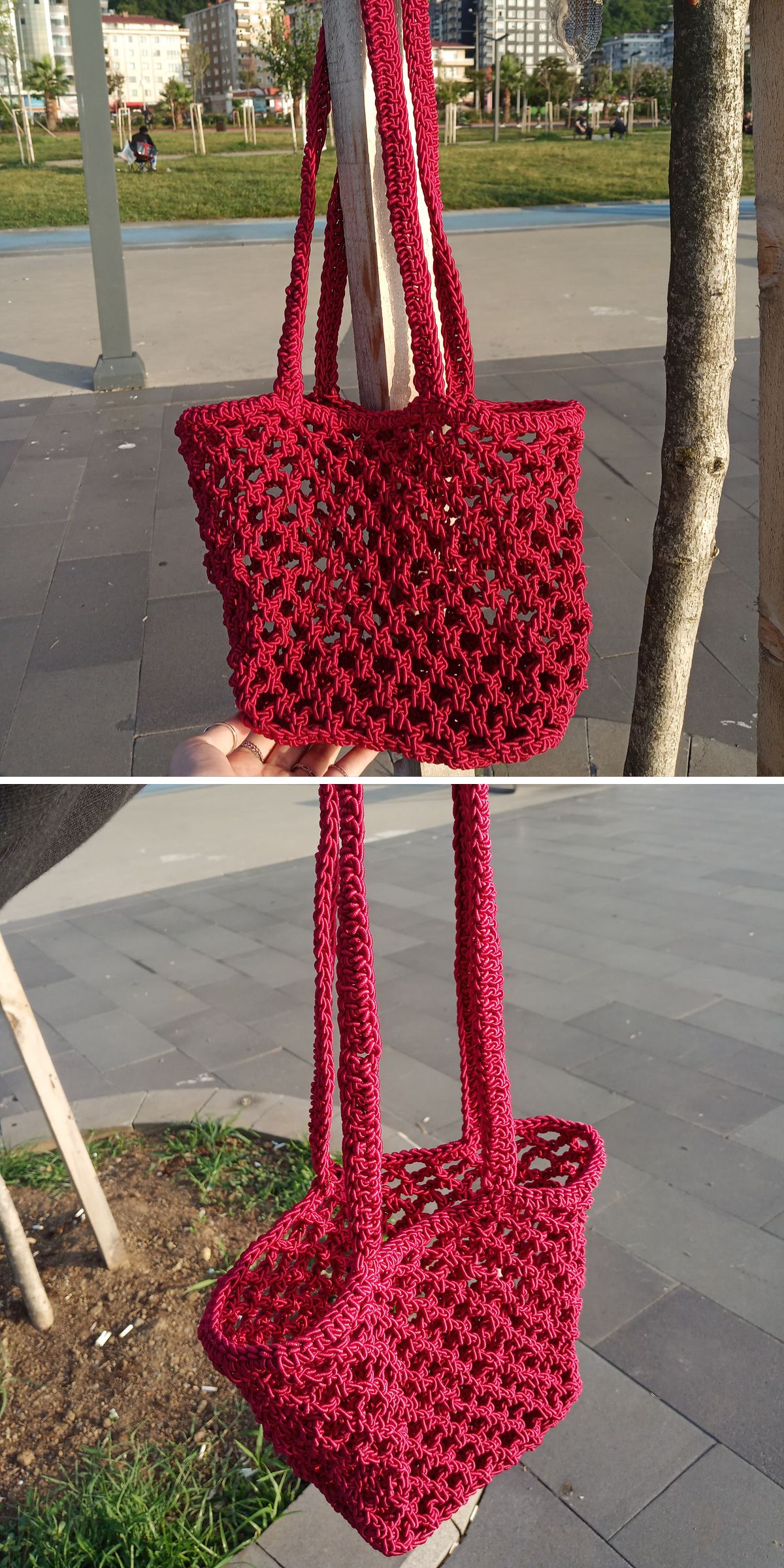 A handmade red Crochet Market Bag with double handles is hanging from a tree branch in an outdoor setting.