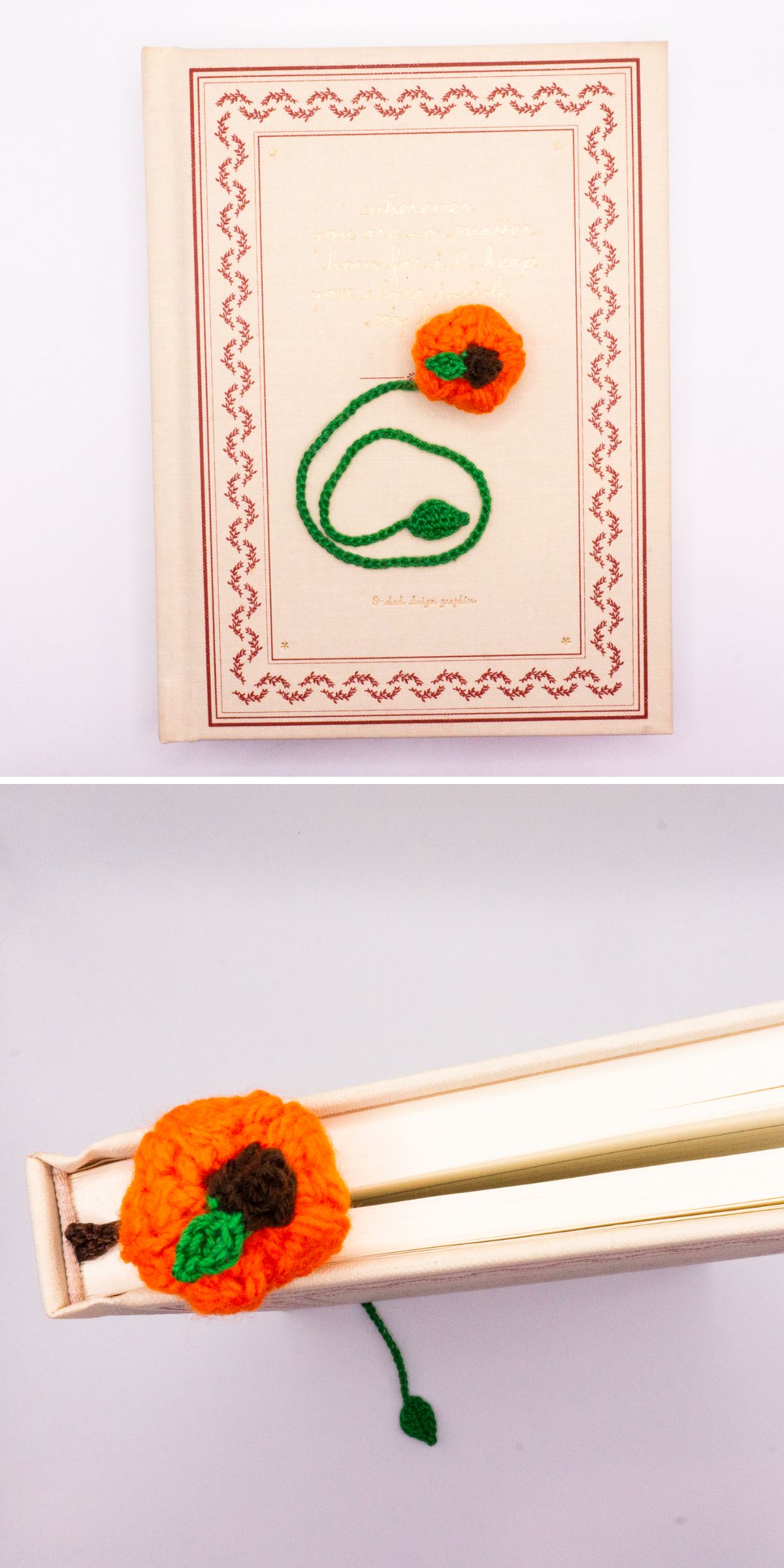 A crochet bookmark shaped like a pumpkin rests on a closed hardcover book, with its vibrant petals and green stem peeking out.