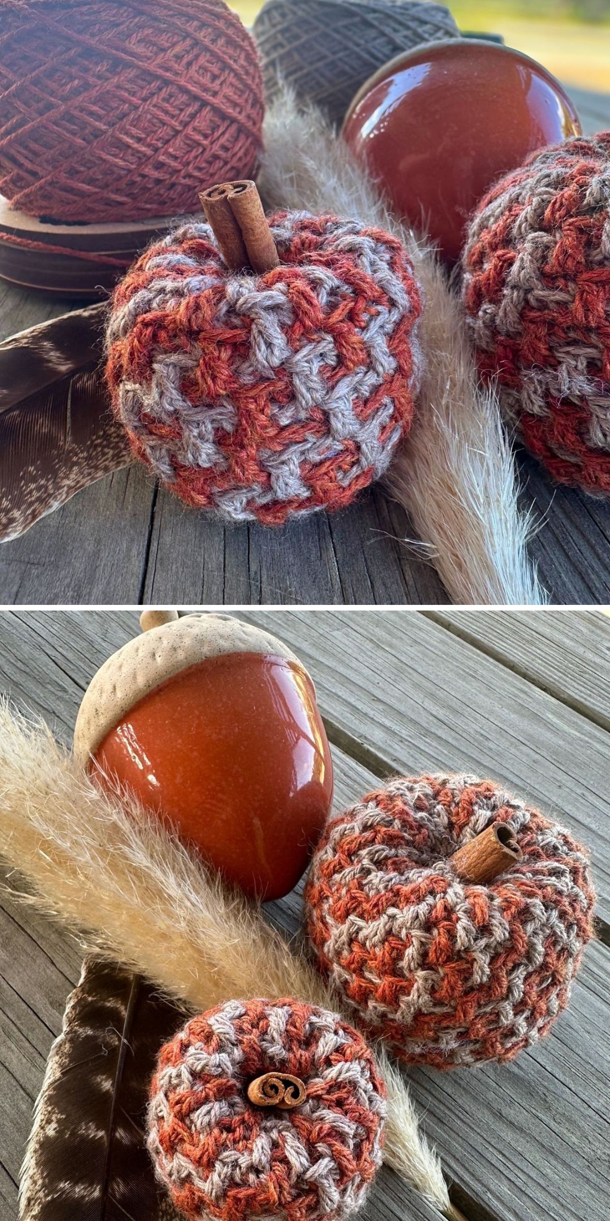Two crochet pumpkins with cinnamon stick stems and a ceramic acorn sit on a wooden surface alongside a feather, dried grass, and a ball of yarn, making this cozy scene perfect for displaying your favorite crochet pumpkin creations.
