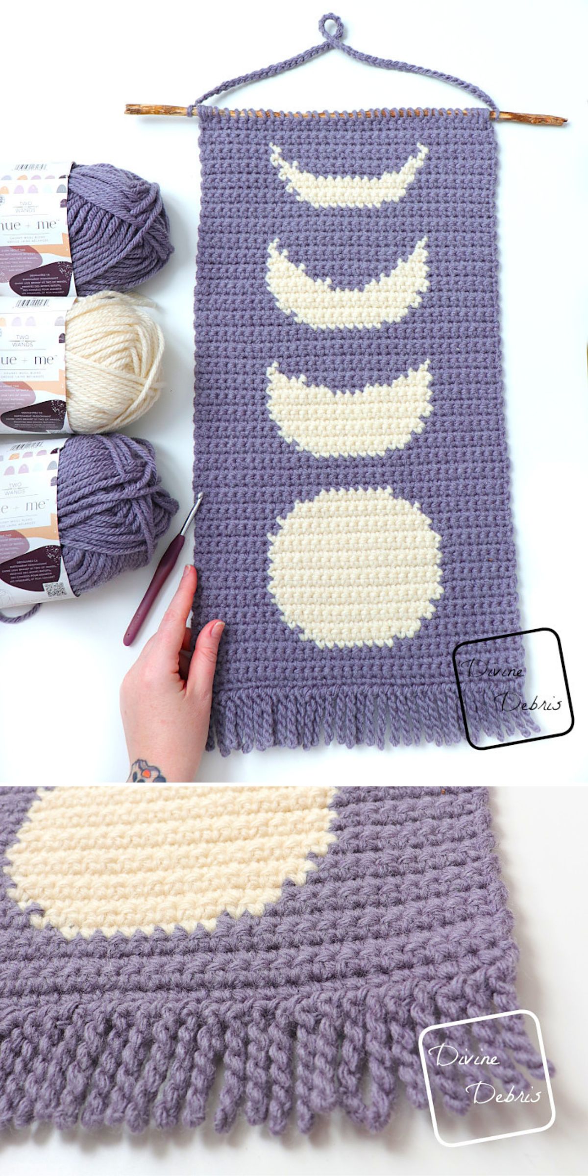 A hand holds a crocheted wall hanging with cream moon phases on a lavender background — perfect crochet home decor. Yarn, a crochet hook, and skeins are nearby; fringe decorates the bottom edge.