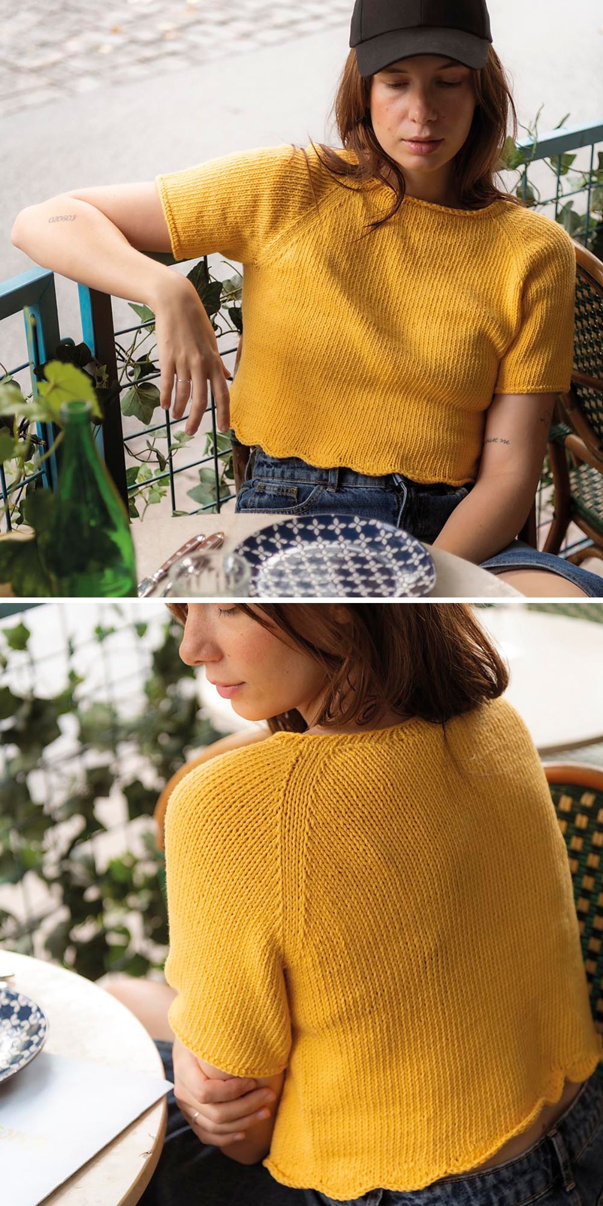 A woman wearing a yellow knit short-sleeve tee top and denim shorts sits at an outdoor table with patterned plates, next to green plants.