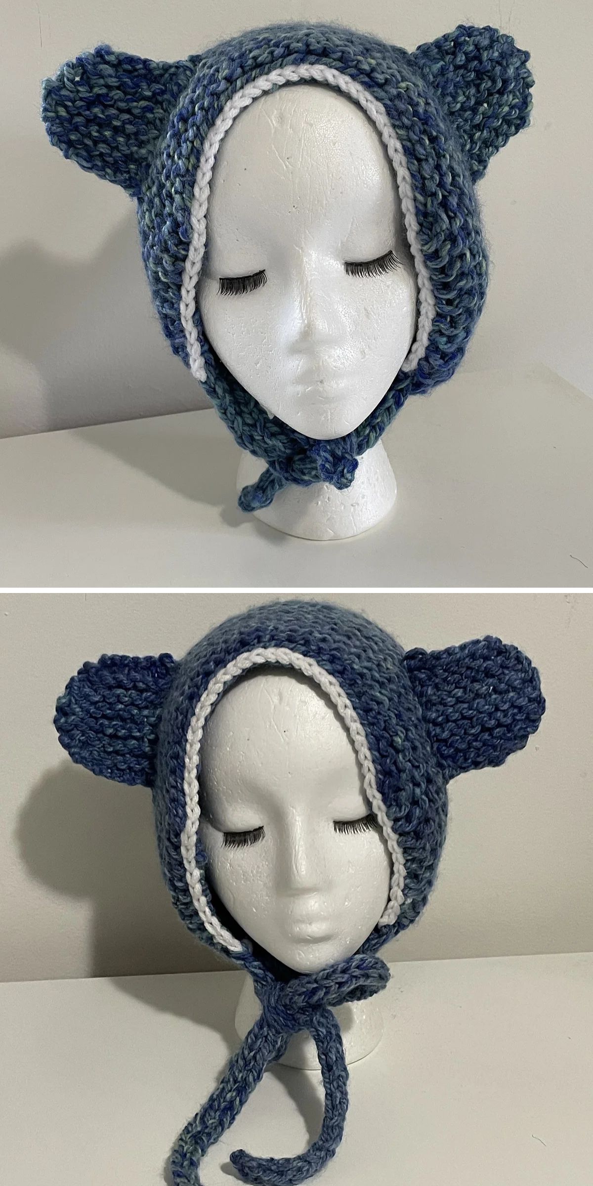 A white mannequin head displays a hand-knitted blue bonnet with bear ears and a white border, tied under the chin with knitted straps—an adorable example of classic knitted baby bonnets.