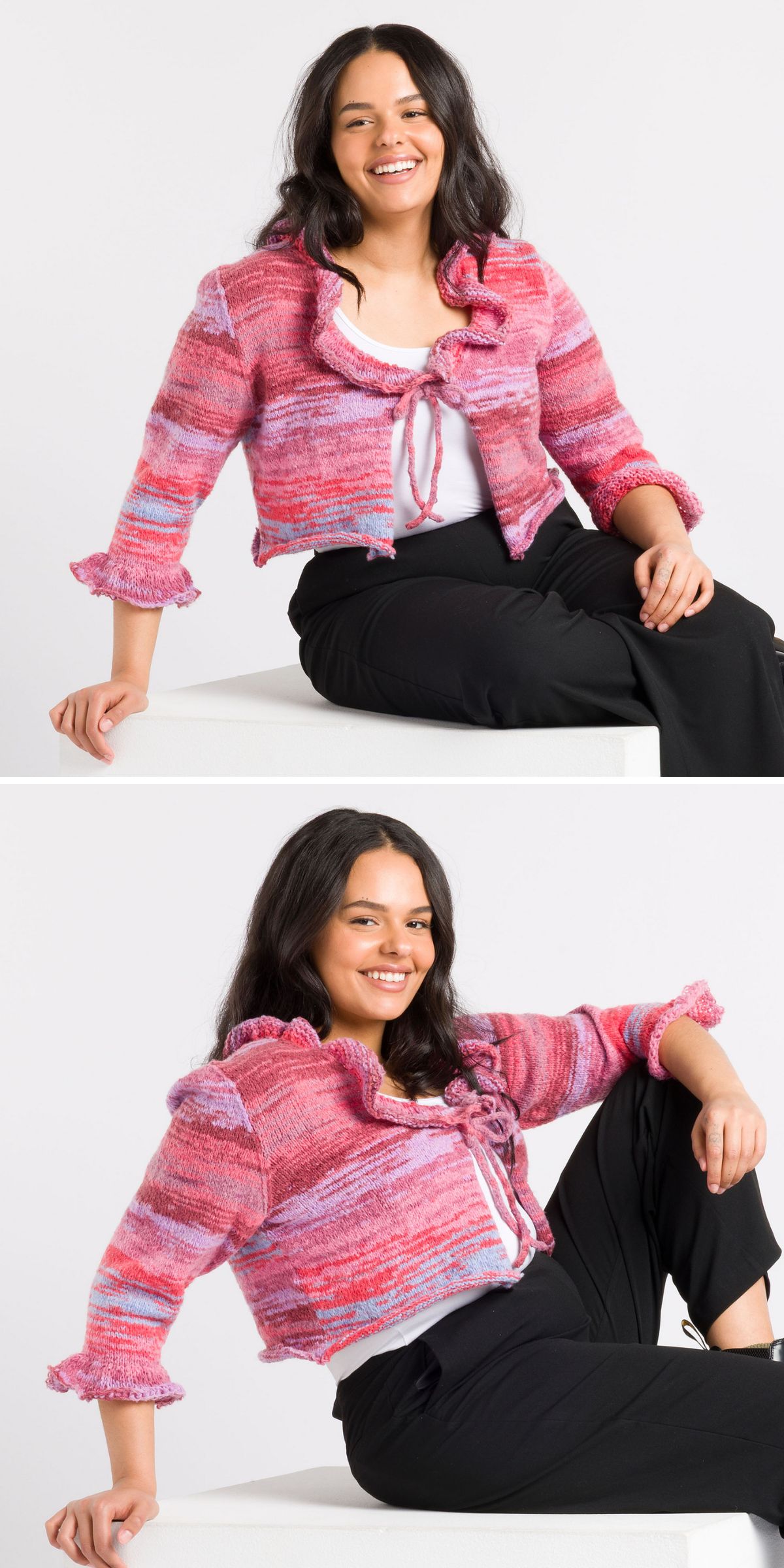 Smiling woman with long dark hair wears a pink and purple textured cardigan over a white top and black pants, posing seated against a plain background.